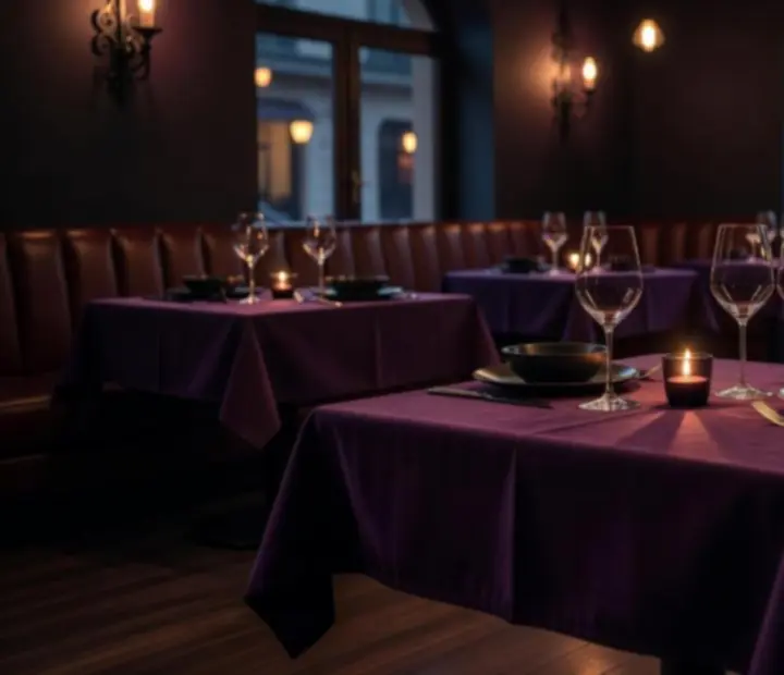 Mesa elegantemente iluminada en un bistro nocturno con copas de vino y luz tenue