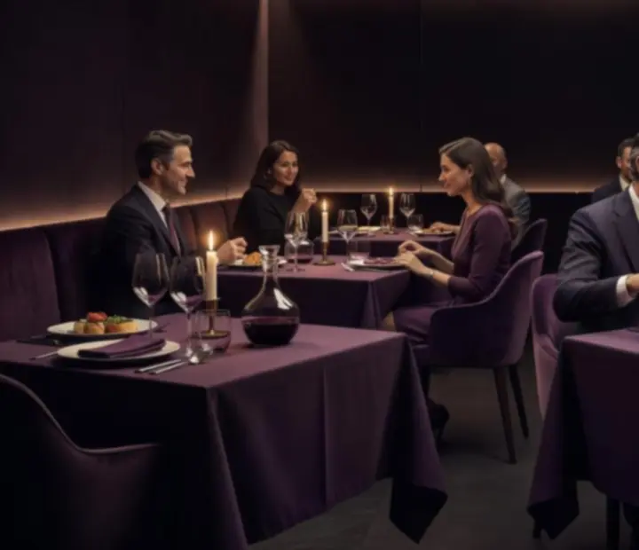 Mesa de restaurante de noche con luz tenue, vajilla elegante y copas de vino en Veladadenaipes
