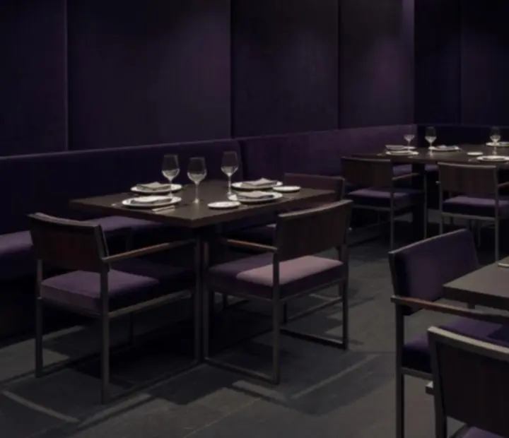 Interior contemporáneo de bistró con mesas vestidas en lino e iluminación tenue