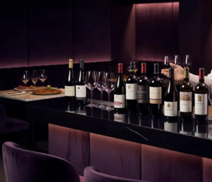 Sommelier sirviendo vino en un bistr&oacute; de ambiente oscuro y elegante